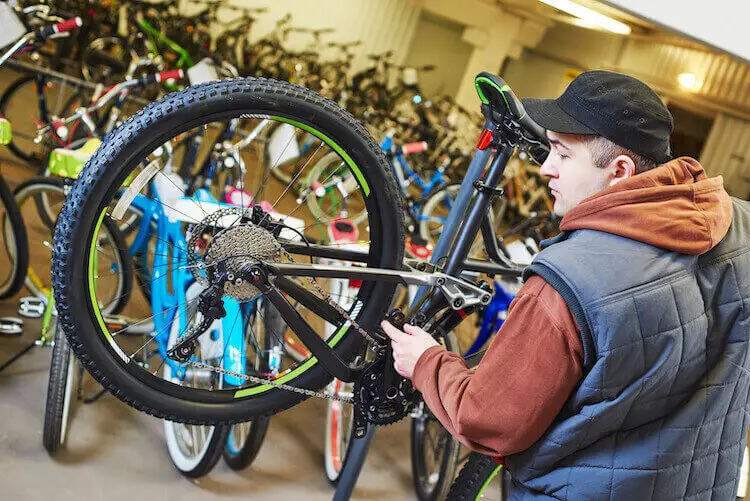 bicycle mechanic fixing bicycle in shop